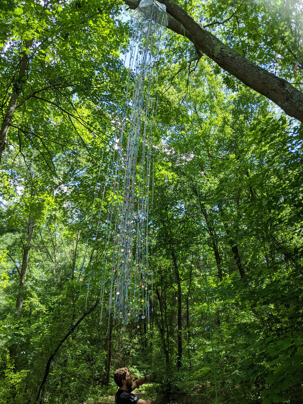 Covered in sequins
Ninety strands of grey ribbon
Hanging from a tree