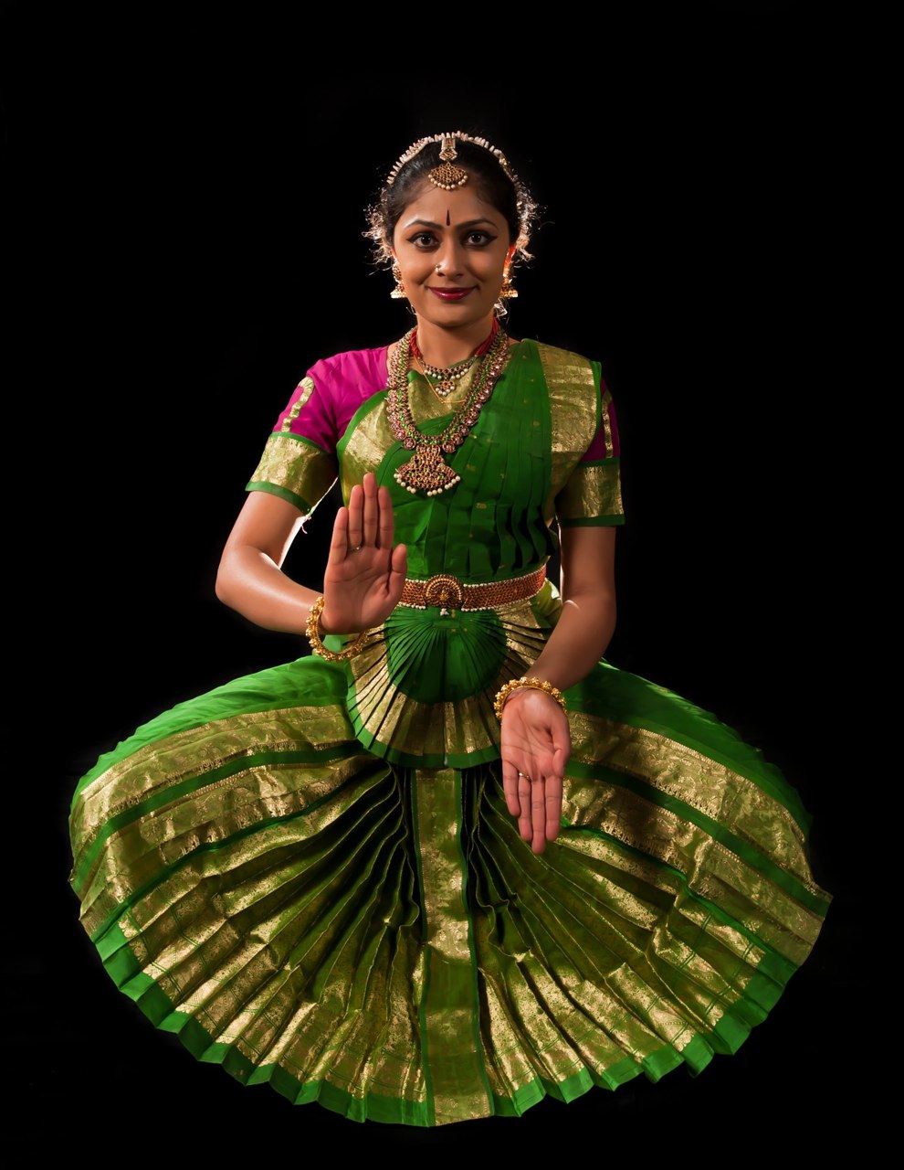 Indian dancer One hand pointed up, one down Wears a green costume