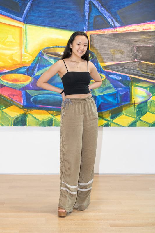 Young Asian woman In front of a bright muralWith hands on her hips