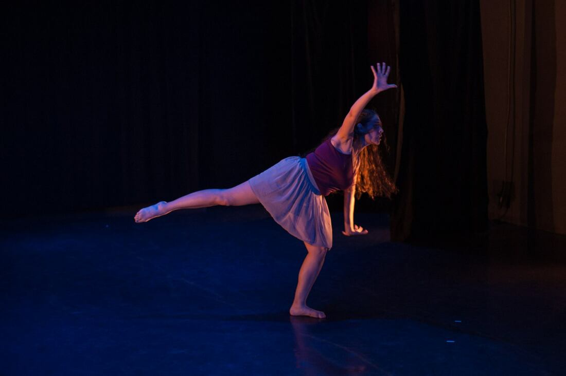 Dancer on a stage One leg to side, arms waving Purple top and skirtPicture