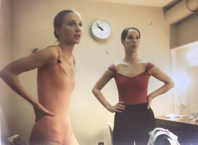 Two dancers standing In dressing room, hands on hips Wearing leotards 