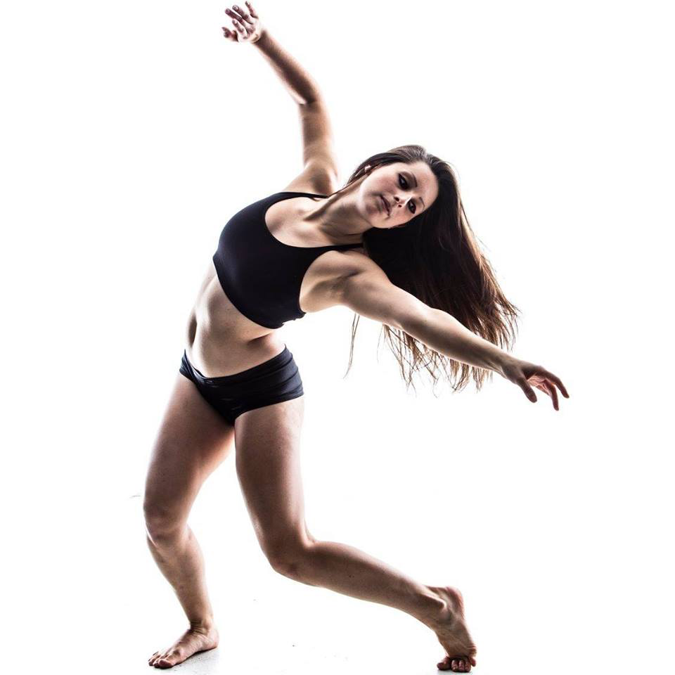 Dancer in white room Long brown hair flowing behind Reaches out and looks 